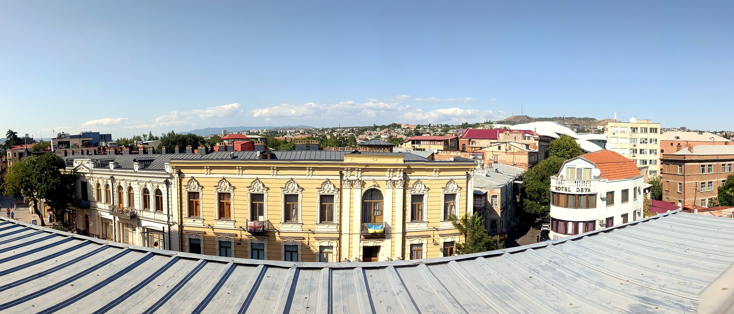 Panoramablick über die Dächer von Tiflis mit historischen Fassaden und Hügeln am Horizont