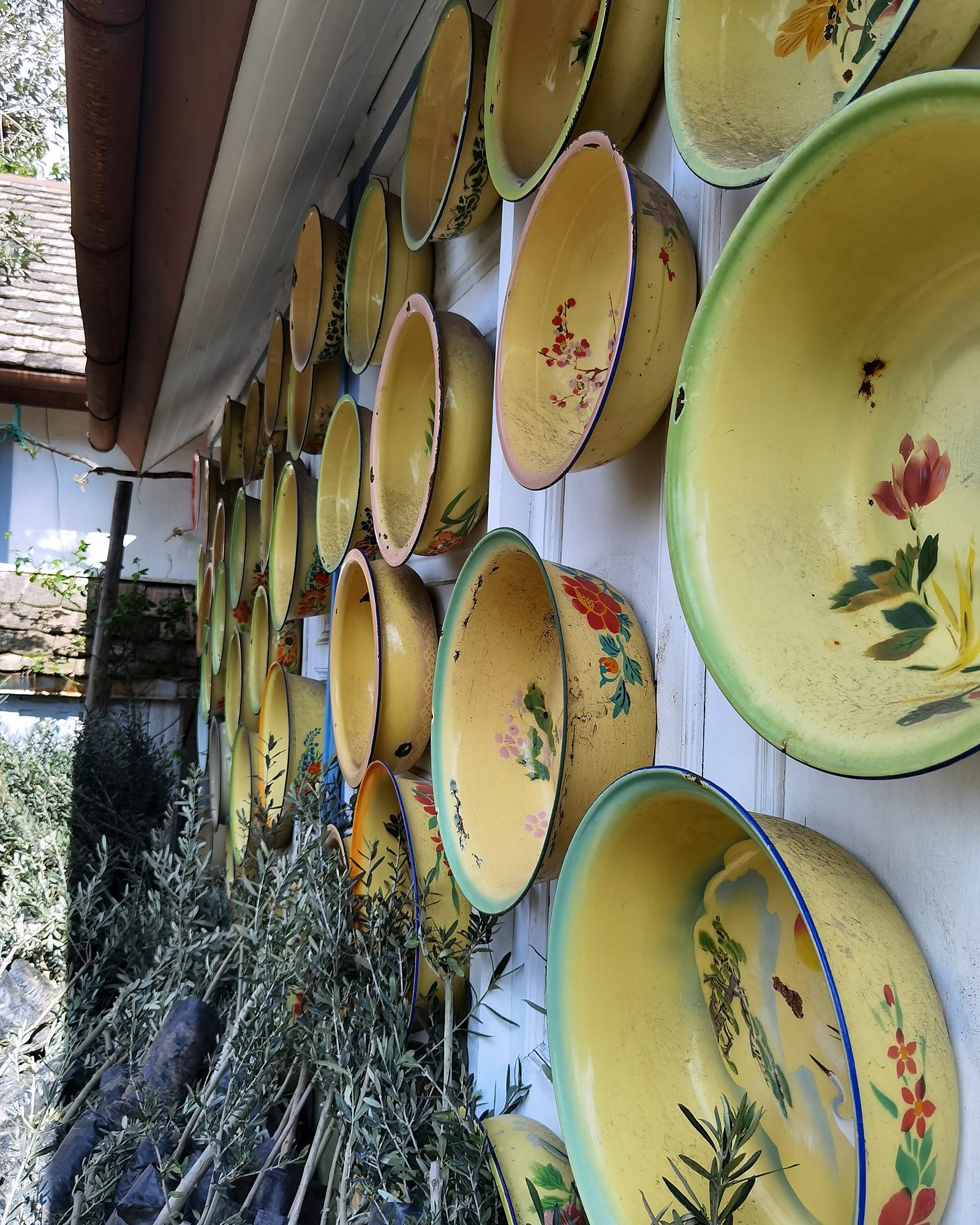 Bemalte Emailleschüsseln an einer Hauswand in Tiflis